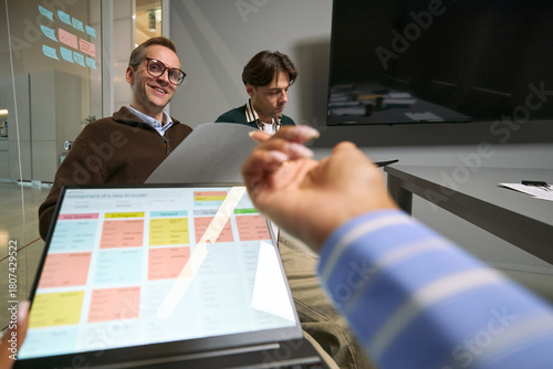 Фотография Caucasian middle aged man smiling and holding paper while sitting at meeting tab