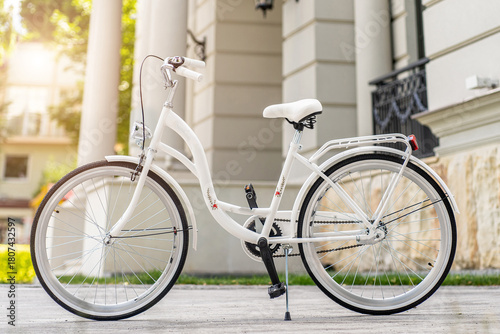 View of urban city bicycle parked on street in neighborhood. Sun bike summer. No people.
