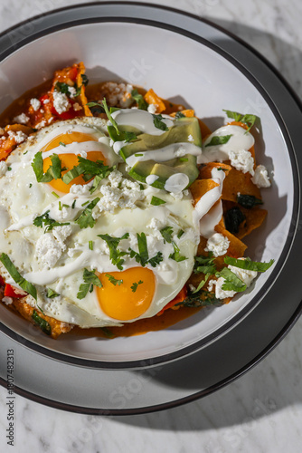 chilaquiles with fried eggs in hard light