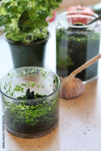 The process of preparing pasta with pesto from spinach, basil, green peas and green parsley: mixing the leaves