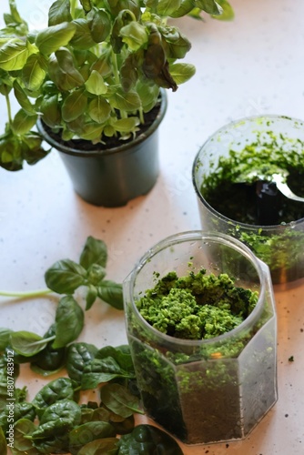 The process of preparing pasta with pesto from spinach, basil, green peas and green parsley: mixing the leaves