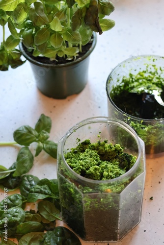 The process of preparing pasta with pesto from spinach, basil, green peas and green parsley: mixing the leaves