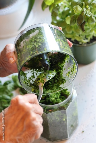 The process of preparing pasta with pesto from spinach, basil, green peas and green parsley: mixing the leaves