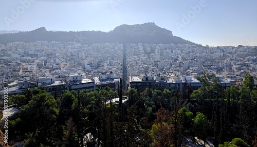 Fototapeta Naklejka Na Ścianę i Meble -  Panoramic view of Athens, Greece, unfolding beneath a vivid blue sky, captured from the summit of Strefi Hill in the heart of Exarcheia neighborhood.