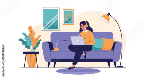 Young woman in headphones is sitting on a sofa and working from home on her laptop computer.