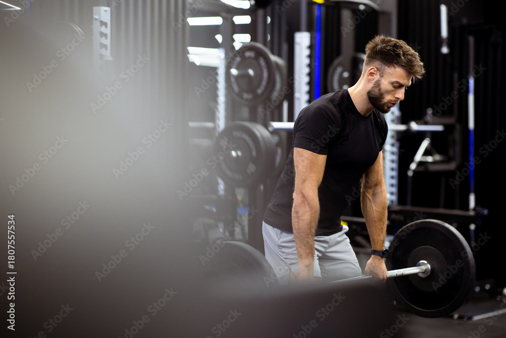 Naklejka premium Weightlifting session at the gym with a focused athlete preparing to lift