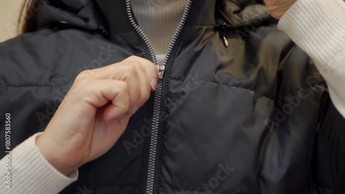 Wallpaper Mural A person's hand pulls the metal zipper slider down quickly on a black quilted vest. The swift action produces a loud, high-pitched zzzip sound. Torontodigital.ca