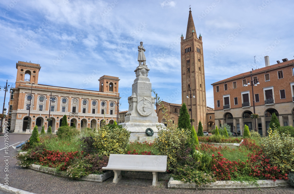 Obraz premium Piazza Aurelio Saffi in Forlì, featuring a tall brick tower, a monument, and historic palazzo architecture.