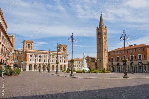 Wide view of Piazza Aurelio Saffi in Forlì, featuring the tall brick tower and historic palazzi.