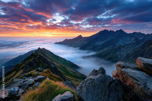 Sunset over mountains with clouds rolling in the valleys during early evening