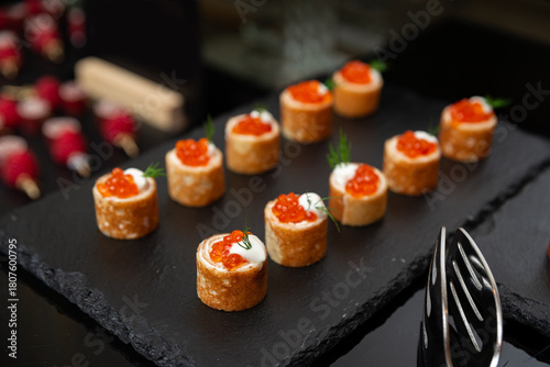 Billede på lærred A beautifully arranged selection of gourmet appetizers featuring salmon roe on a slate platter