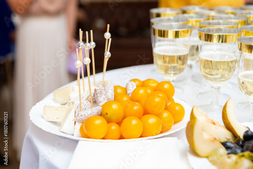 Fotografie A beautifully arranged platter featuring cheese cubes, skewered salami, and vibrant yellow tomatoes