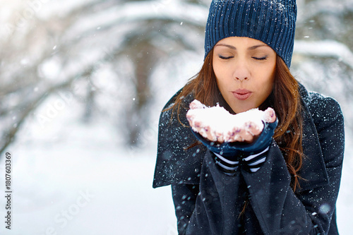 Woman Blowing Snowflakes in Winter Park