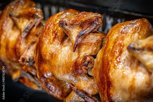 Tableau sur toile Barbecue roast Chicken in a row turning at industrial roaster grill