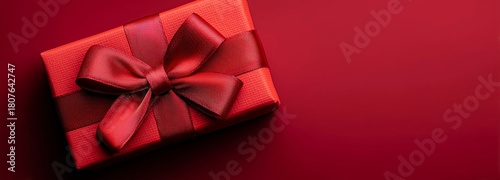Gift Box With Brown Ribbon on a Textured Red Background Ready for Celebration