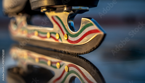 Farben grün, weiß, rot auf gespiegelter Kufe eines Schlittschuhs - Nahaufnahme mit Farben der Tricolore