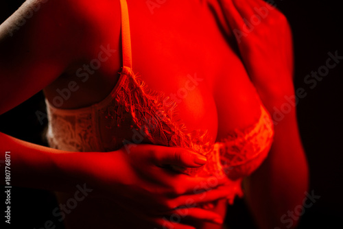 Sexy woman poses in lingerie under glowing red neon lights at night