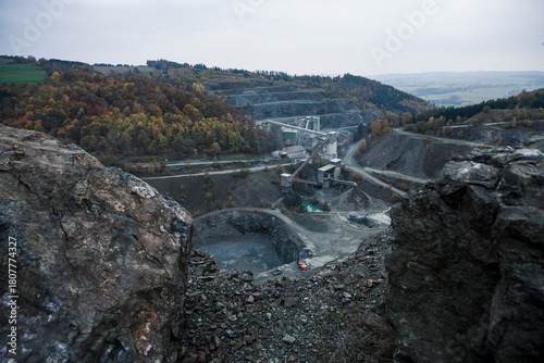 Open pit mine in the fall with yellowing trees in the distance