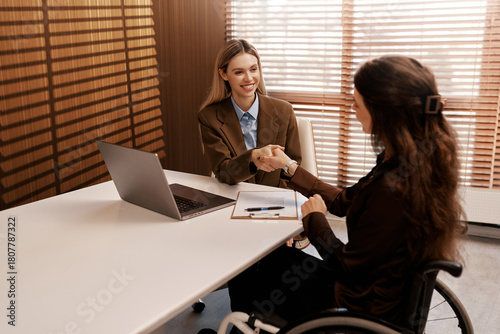 Job interview handshake with disabled woman in wheelchair