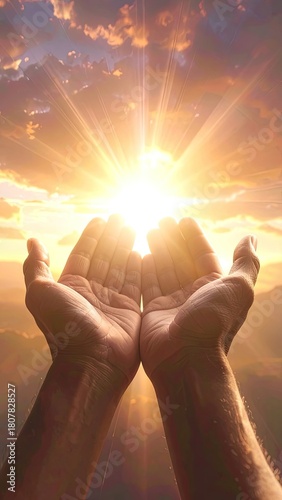 Hands holding the sun's radiant light in a beautiful, cloudy sky at sunrise