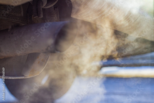 Close-up of car smoking exhaust pipe, car with gasoline engine. Gasoline engine warming up at idle in winter season. Blue exhaust smoke