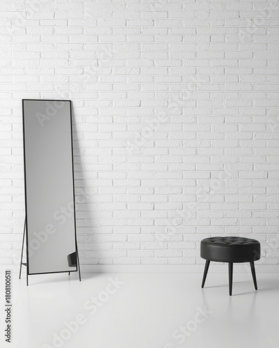 Minimalist interior with a full-length mirror and a black stool against a white brick wall