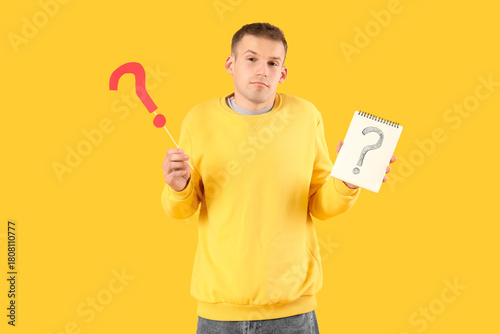 Young man with paper questi...