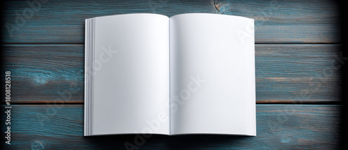 An empty, open book with blank white pages lies on a textured, dark blue wooden surface, inviting the viewer to fill it with their own content