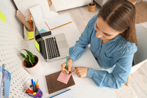 Young woman making to-do li...