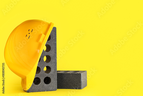 Bricks with helmet on yello...