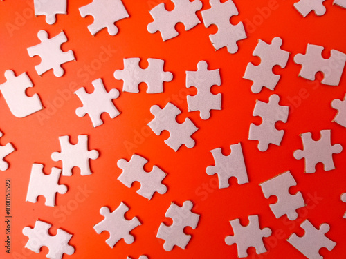 The image shows several pieces of a jigsaw puzzle on a orange background