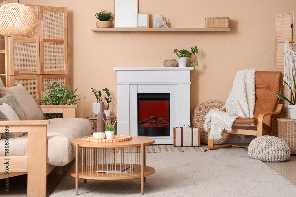Fototapeta premium Fireplace, sofa, table and leather armchair near beige wall in interior of living room
