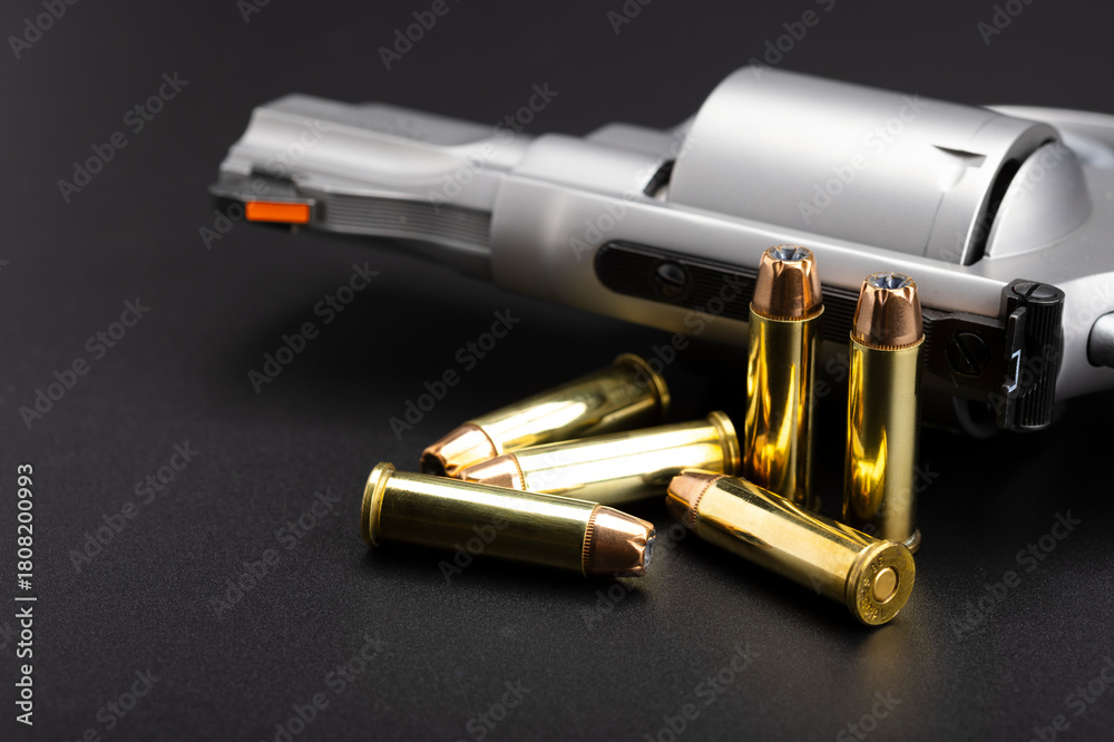 Fototapeta premium Hollow-point .38 Special bullets with revolver gun on black background , Classic bullets for revolver handgun , more performance .38 special ammunition
