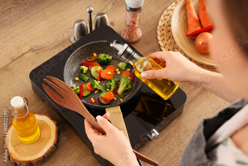 Woman frying vegetables wit...