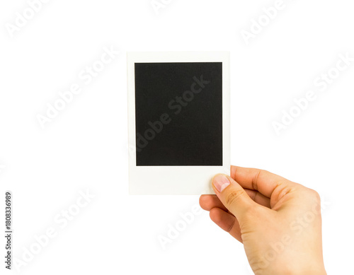 Hand holding blank polaroid frame photo isolated on black background on transparent background