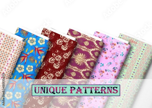 Assortment of colorful patterned fabrics rolled and placed diagonally on a white surface studio shot