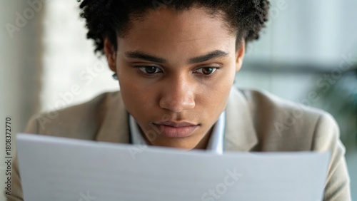 Focused woman examining documents with an intent expression in a professional setting.
