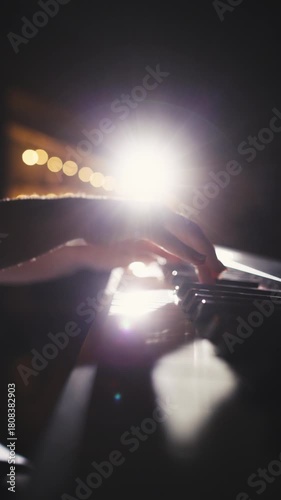 vertical slow motion macro shot of female pianist performing graceful movement on piano keys concept of creative passion art of sound focus and inspiration under warm studio light