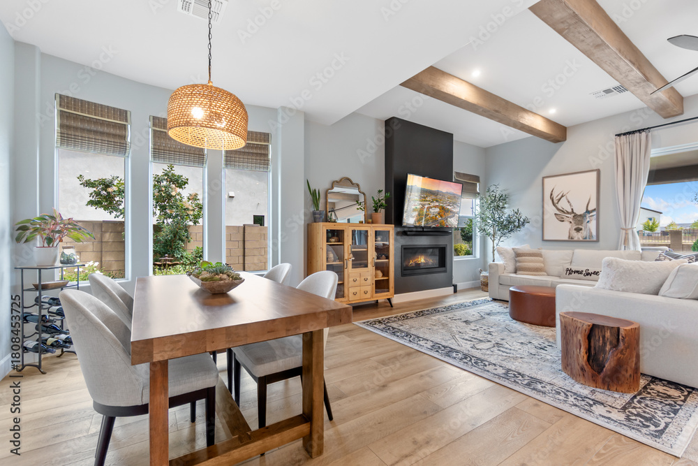 Naklejka premium A welcoming living room featuring a wooden table, chairs, and a cozy fireplace