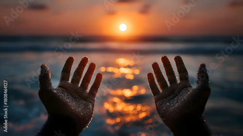 Fototapeta Naklejka Na Ścianę i Meble -  Silhouetted Hands Reaching Towards Golden Sunset Over Ocean Waves