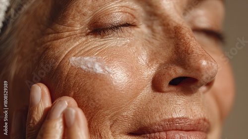 A woman applying moisturizer to her face, enjoying a moment of self-care and rejuvenation. Emphasis on natural beauty and skincare routine.
