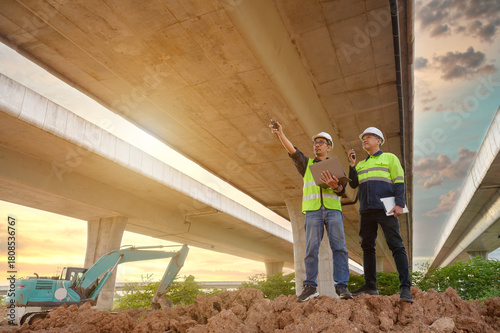 Civil engineers inspect elevated highway structure at infrastructure construction site. Supervise new road construction, structural inspection, construction work in Thailand Asia.