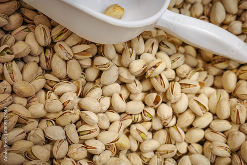 Scoop of pistachios in bulk healthy nuts background