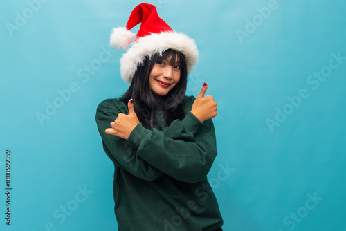 Joyful woman in Santa hat crosses arms showing satisfaction Ideal for confident Christmas advertising and seasonal campaigns