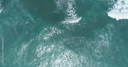 Aerial view of the sea surface with surging waves from a bird's-eye view.