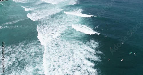 Surfers on the sea surface with surging waves.