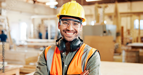 Carpentry, happy and portrait of man in workshop for furniture repair, building and woodworking. Carpenter, safety gear and person with crossed arms in factory for wood, lumber and timber production
