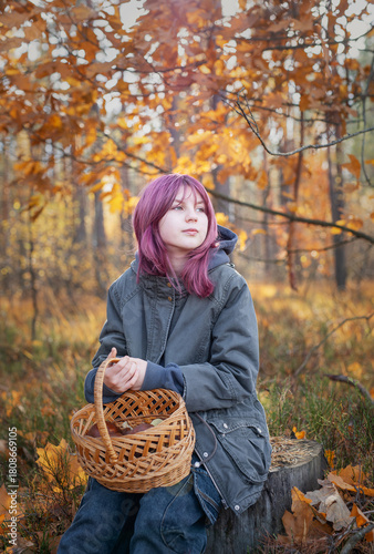 Young girl holding mushroom basket in autumn forest