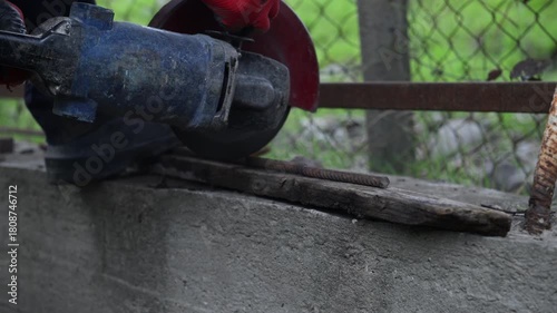 Workers are sawing rebar on concrete with a saw blade on an autumn day