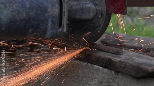 Workers are sawing rebar on concrete with a saw blade on an autumn day